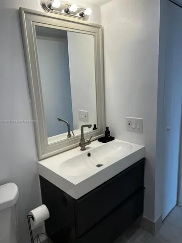 a bathroom with a sink vanity and toilet