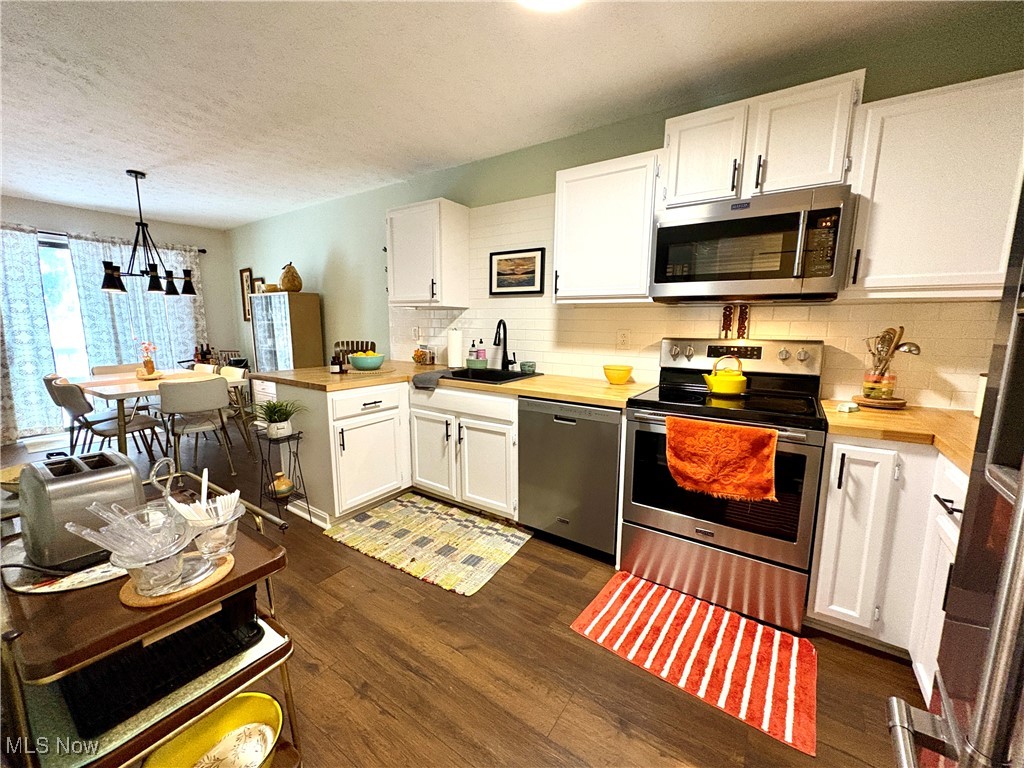 4015 Marks Road, Unit 3C Medina, OH 44256 - Photo 12 of 36 Kitchen with stainless steel appliances, sink, pendant lighting, an inviting chandelier, and white cabinets