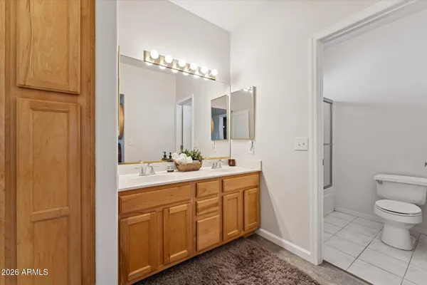 a spacious bathroom with a toilet a sink and mirror