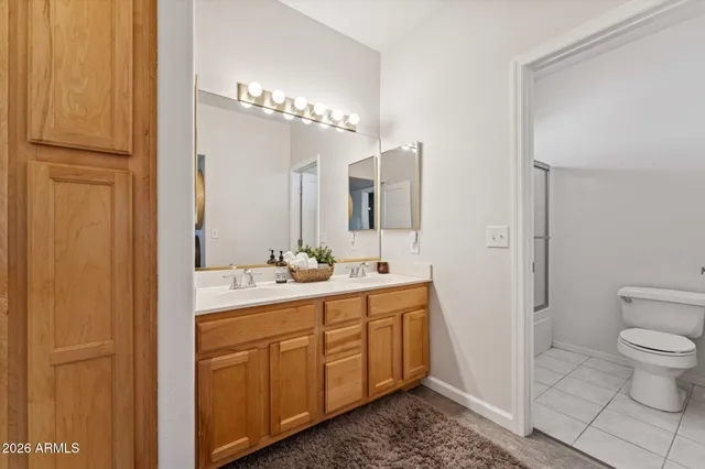 a spacious bathroom with a toilet a sink and mirror