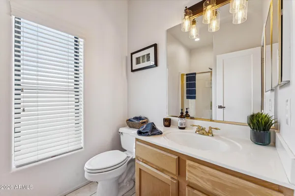 a bathroom with a granite countertop sink mirror and toilet