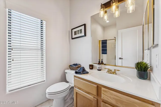a bathroom with a granite countertop sink mirror and toilet