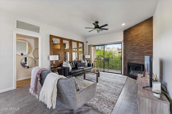 a living room with furniture large window and a fireplace