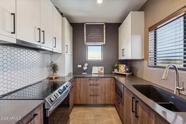 a kitchen with granite countertop a sink stove and cabinets