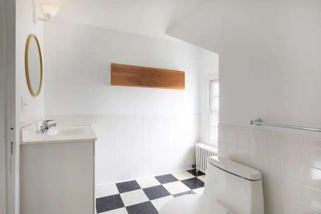 a bathroom with a sink a toilet and a mirror