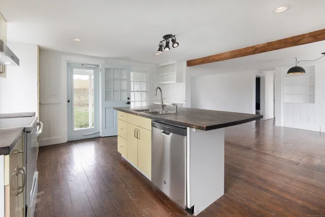 a kitchen with a sink cabinets and wooden floor