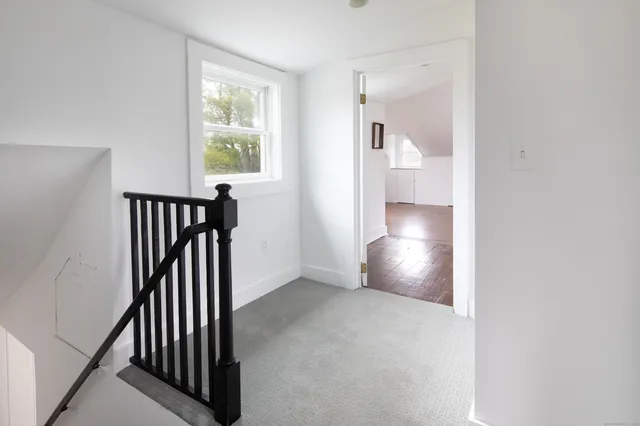 a view of entryway and hall with wooden floor