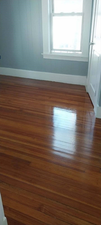 53 Foster Street Springfield, MA 01105 - Photo 3 of 11 a view of empty room with window and wooden floor