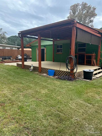 a view of a house with backyard porch and furniture