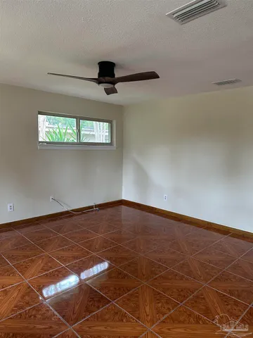 a view of a room with a ceiling fan and wooden floor