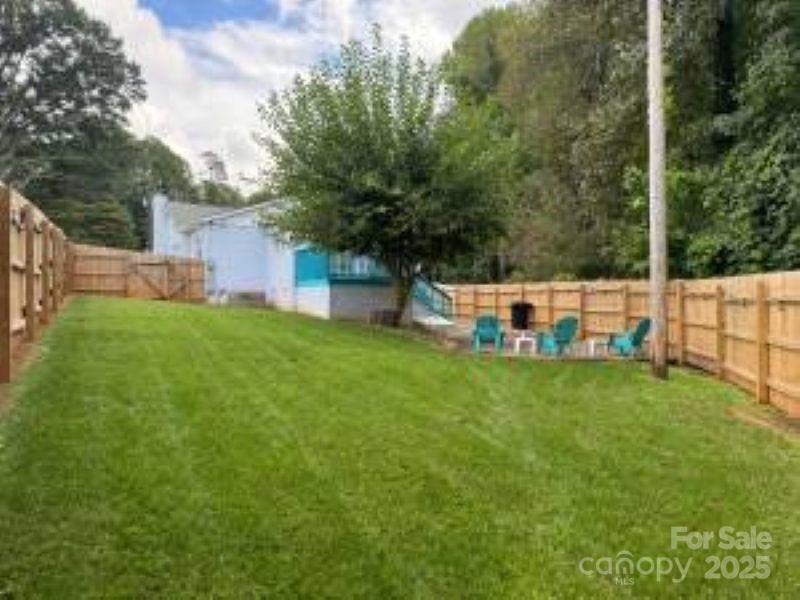 318 Lake Montonia Road Kings Mountain, NC 28086 - Photo 23 of 23 a backyard of a house with table and chairs plants and large trees