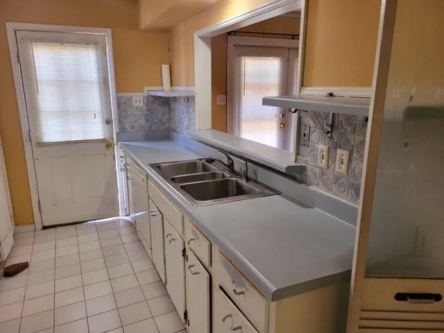 a kitchen with a refrigerator a sink a stove a microwave a counter top space and cabinets