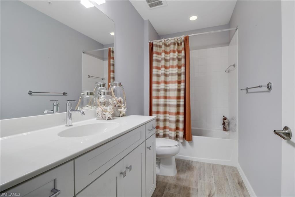 6973 Avalon Circle, Unit 1403 Naples, FL 34112 - Photo 14 of 37 Full bathroom with shower / tub combo, vanity, and wood finish floors