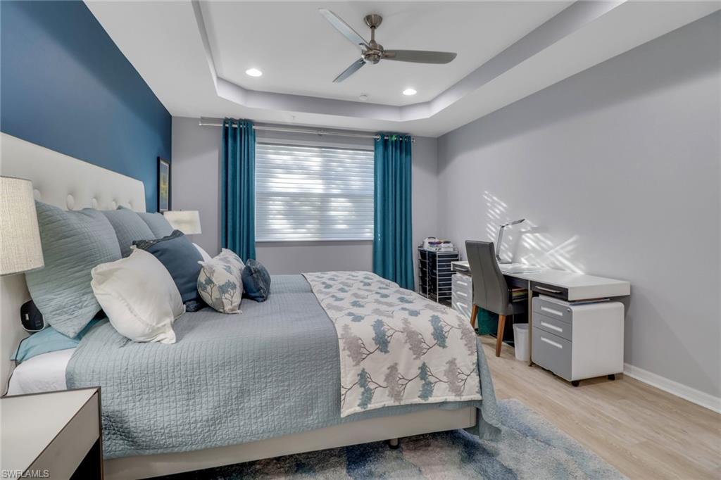 6973 Avalon Circle, Unit 1403 Naples, FL 34112 - Photo 16 of 37 Bedroom featuring light wood-style floors, a raised ceiling, a ceiling fan, and recessed lighting