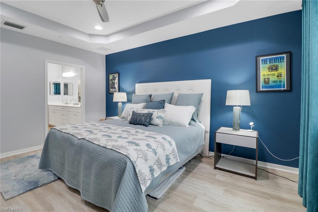 6973 Avalon Circle, Unit 1403 Naples, FL 34112 - Photo 17 of 37 Bedroom with a raised ceiling, wood finished floors, a ceiling fan, and ensuite bathroom