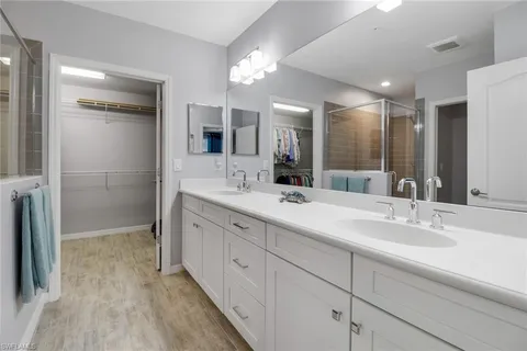 a bathroom with double vanity sink and a mirror