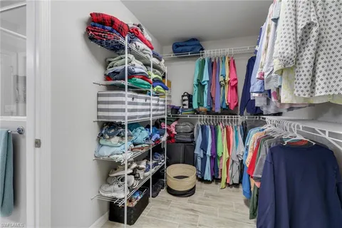 a view of walk in closet with clothes