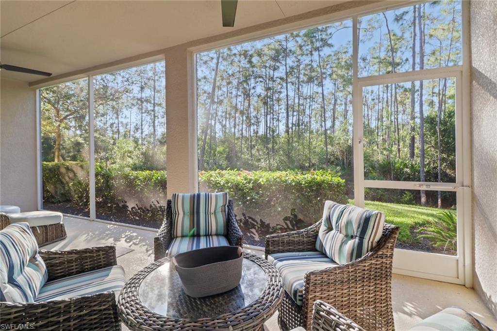 6973 Avalon Circle, Unit 1403 Naples, FL 34112 - Photo 22 of 37 Sunroom featuring a ceiling fan, an outdoor hangout area, and view of wooded area
