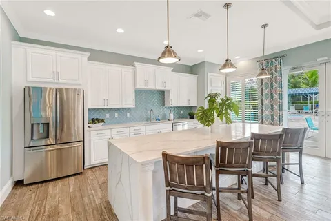 a kitchen with stainless steel appliances granite countertop a kitchen island a stove a table and chairs