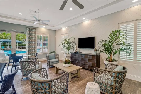 a living room with furniture a flat screen tv and a large window