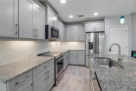 a kitchen with a sink a refrigerator and cabinets