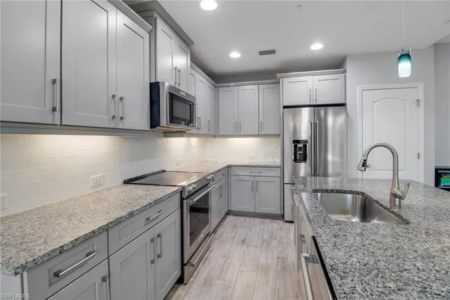 a kitchen with a sink a refrigerator and cabinets