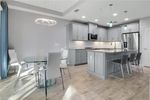 a kitchen with kitchen island granite countertop wooden cabinets and chairs
