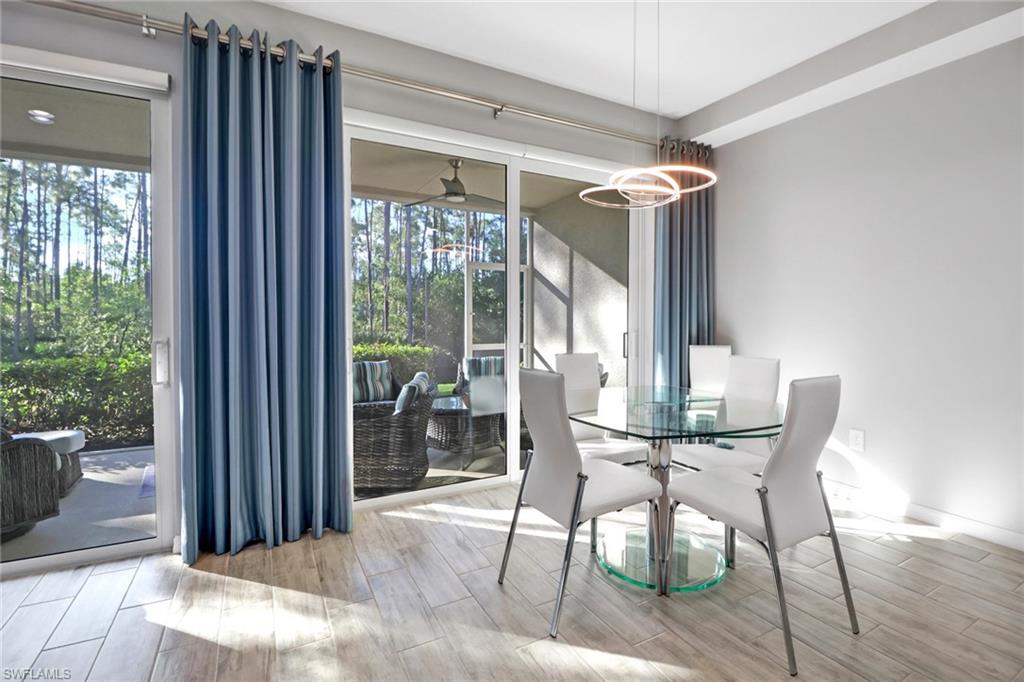 6973 Avalon Circle, Unit 1403 Naples, FL 34112 - Photo 6 of 37 Dining area featuring wood finish floors and healthy amount of natural light