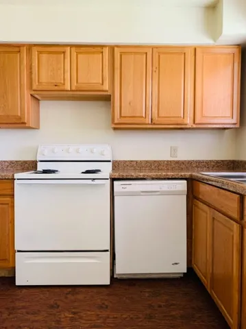 a kitchen with granite countertop cabinets and wooden floor