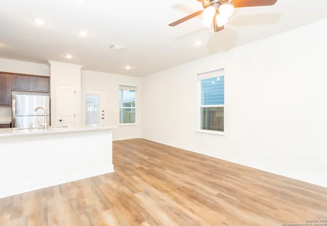 a view of an empty room with window and wooden floor