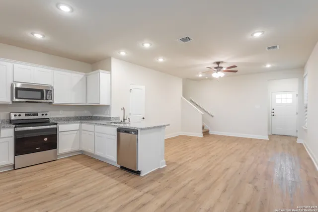 a kitchen with granite countertop a stove top oven and cabinets