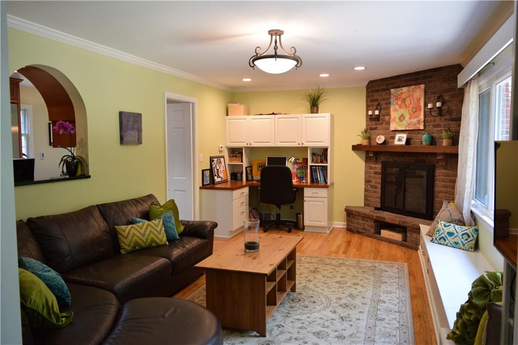 406 Buckingham Road Fox Chapel, PA 15215 - Photo 11 of 25 A lovely rustic brick fireplace with energy-efficient ventless gas logs brings warmth to the bright family room. Note the large picture window. Built-ins and a window seat provide additional storage.