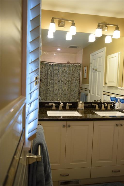 406 Buckingham Road Fox Chapel, PA 15215 - Photo 16 of 25 Double sinks, a large mirror and timeless subway tiles accent the renovated hall bath.