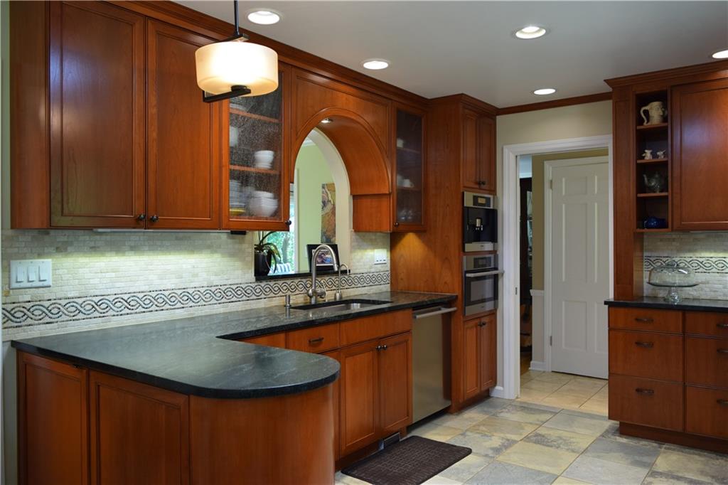 406 Buckingham Road Fox Chapel, PA 15215 - Photo 7 of 25 This artfully remodeled kitchen truly is the heart of the home with its warm-toned cherry cabinetry, elegant soapstone countertops, and travertine backsplash. Ample counter space facilitates multiple cooks. The Miele coffee center lets you be your own barista: start your day with a latte or indulge your guests with an after dinner espresso. A super quiet Miele dishwasher and extra large stainless sink make for quick and easy cleanup.
