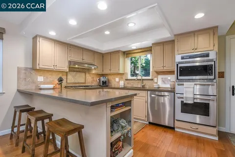 a kitchen with kitchen island a counter top space cabinets and stainless steel appliances