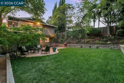 a patio with table and chairs and potted plants