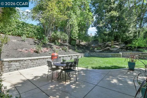 a view of a house with backyard and trees