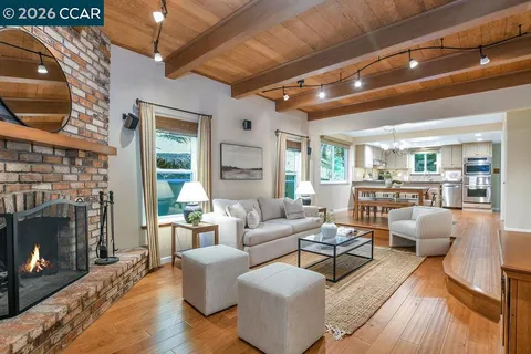 a kitchen with stainless steel appliances granite countertop a stove top oven a refrigerator a sink and a dining table with wooden floor