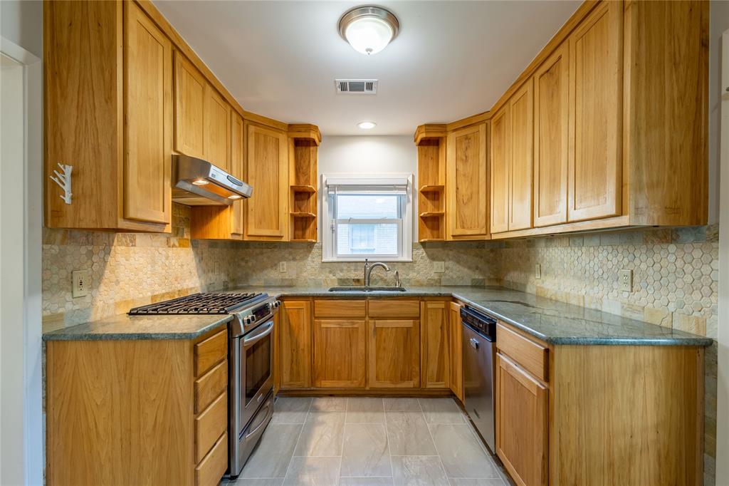 6165 Ravendale Lane Dallas, TX 75214 - Photo 15 of 40 a kitchen with stainless steel appliances granite countertop wooden cabinets a sink and dishwasher a stove with wooden floor