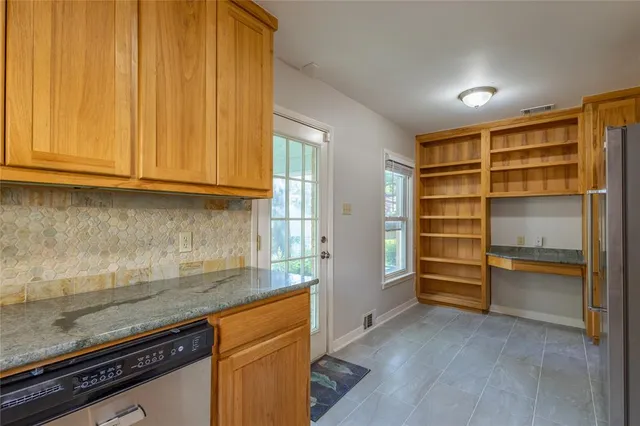 a kitchen with granite countertop a refrigerator and a sink