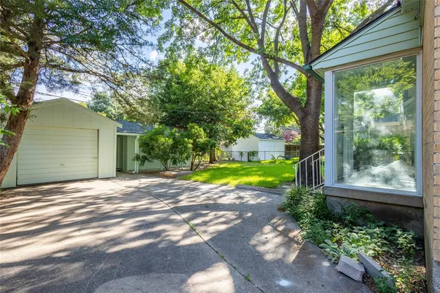 a view of a house with a backyard and a tree