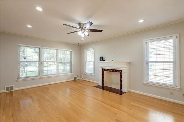 a view of an empty room with a window and a fireplace