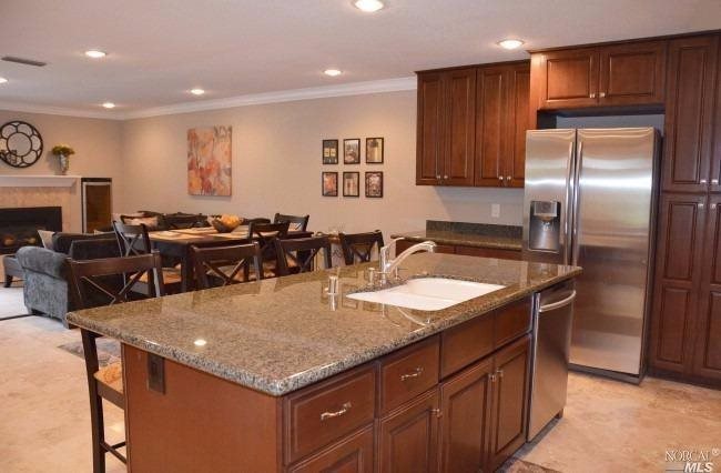 a kitchen with stainless steel appliances granite countertop a sink a microwave and a refrigerator