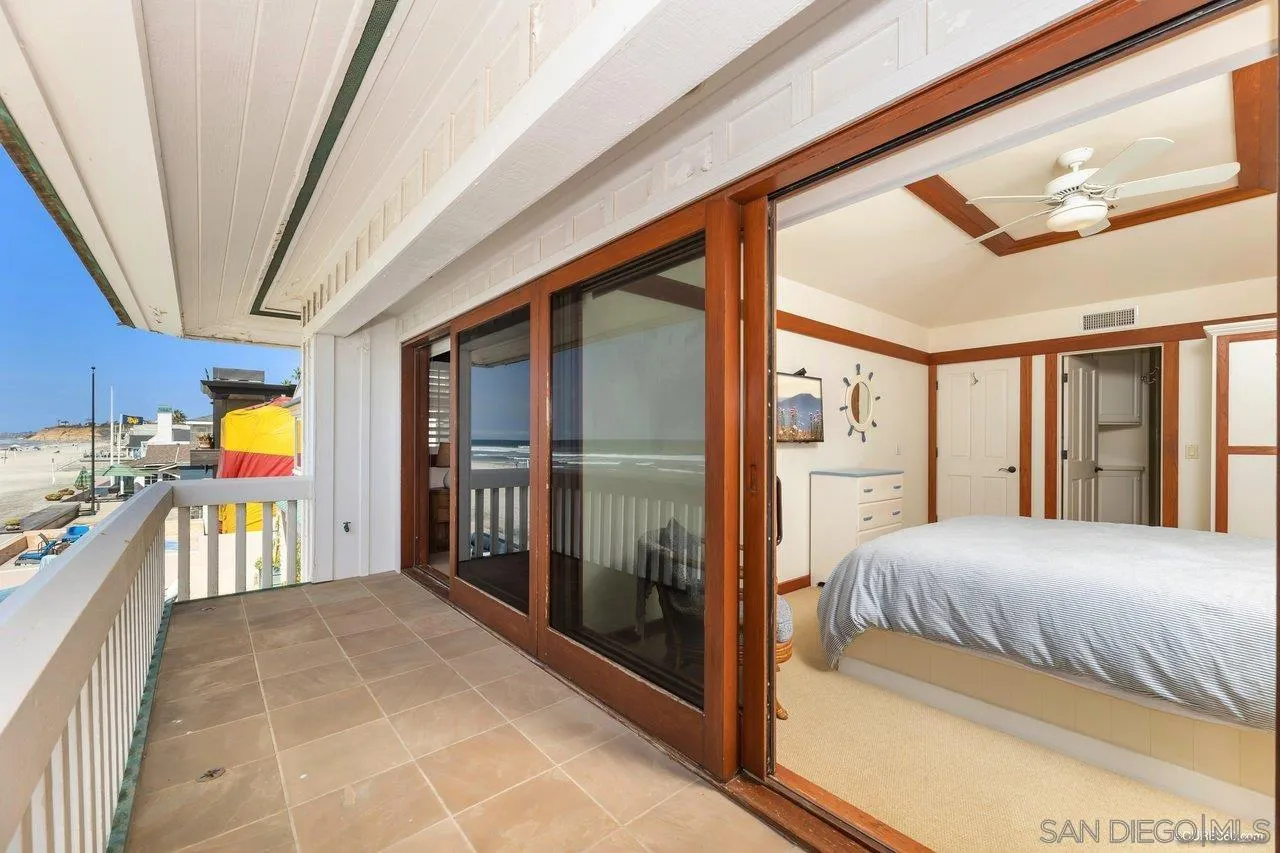 2008 Ocean Front Del Mar, CA 92014 - Photo 12 of 35 a bedroom with a bed and a large mirror with a large window