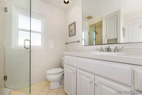 a bathroom with a granite countertop sink a toilet and a mirror