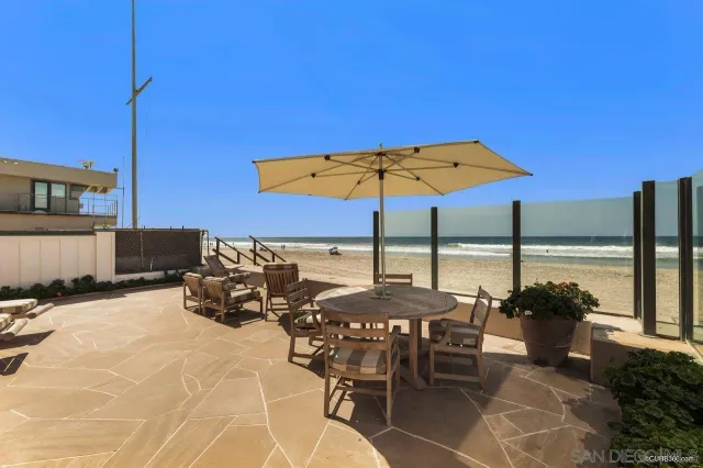 a view of a patio with a table and chairs under an umbrella