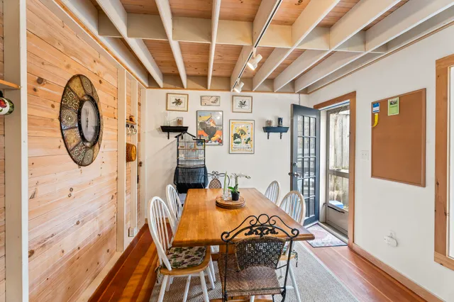 a view of a dining room with furniture front door and wooden floor