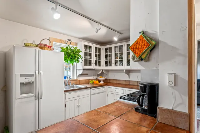 a kitchen with stainless steel appliances granite countertop a refrigerator and a sink