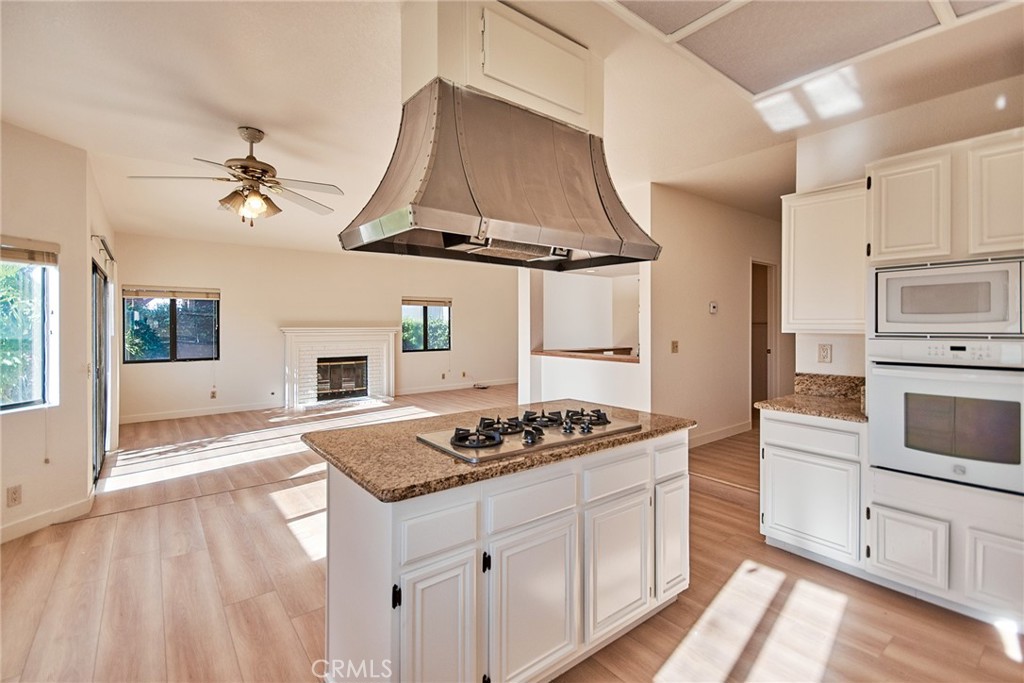 24352 East Rimford Place Diamond Bar, CA 91765 - Photo 14 of 31 a kitchen with stainless steel appliances a stove a sink dishwasher and white cabinets with wooden floor