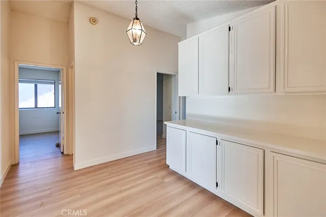 a view of a kitchen with wooden floor and electronic appliances